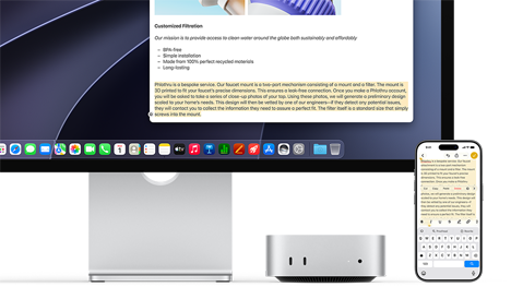 Mac mini de face, glissé sous un Studio Display, un iPhone se trouve à droite de l’appareil et de l’écran, du texte sélectionné avec les commandes Couper, Copier, Coller et Remplissage automatique en haut de l’iPhone correspond au texte surligné à l’écran, illustrant le fonctionnement du presse-papiers universel