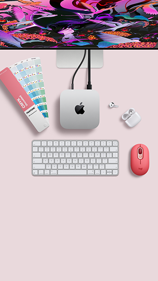 Mac mini, dessus, aluminium argent, angles arrondis, logo Apple noir brillant centré, connecté par un câble, Studio Display partiellement visible en haut, AirPods 4, boîtier ouvert, pastilles de couleur Pantone, et clavier et souris Logitech rouges
